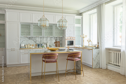 a close view of the white stylish kitchen with a cooking island in the luxurious interior of a modern apartment in light colors with stylish furniture. © 4595886