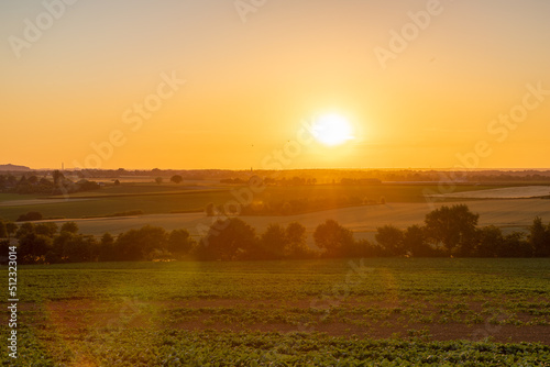 A golden sunset over the rolling hills in Banholt  south Limburg in the Netherlands creating holiday vibes. The views and the warm glow over the landscape create a feeling of being in the Mediterranea