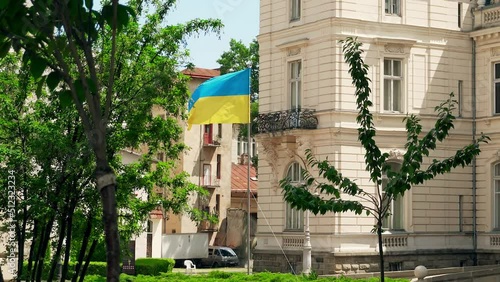 Summer, Potocki Palace in Lviv, flag of Ukraine in the wind. The yellow-blue flag is a symbol of Independence and resilience photo