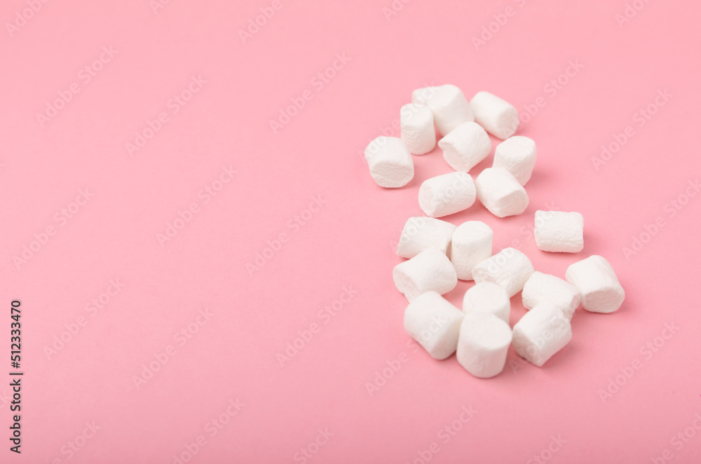 Loose marshmallows on a pink background. White marshmallow flat lay. Sweets and snacks for a snack. Chewing candies close-up. Copy space. Place for text. Winter food concept. Loose marshmallows on a pink background. White marshmallow flat lay. Sweets and snacks for a snack. Chewing candies close-up. Copy space. Place for text. Winter food concept.