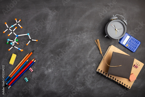 Back To School and education Concept. Alarm clock and over supplies on blackboard background. Copy Space, top view flat lay