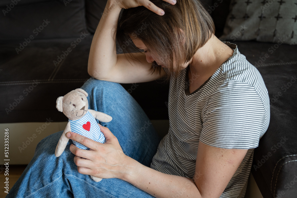 Perinatal loss reproductive chalenge concept - female holding a teddy bear toy - obrazy, fototapety, plakaty 