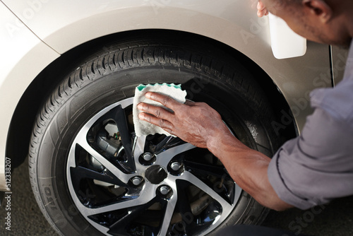 Close-up image driver cleaning aluminum wheels with soft cloth to make it shine © DragonImages