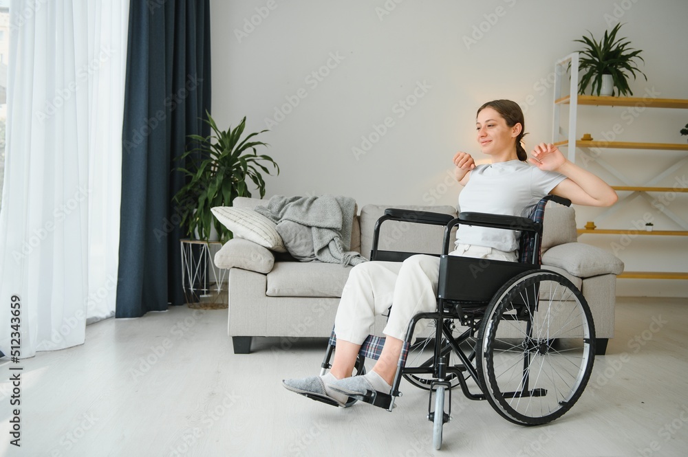 Brunette woman working out on wheelchair at home Brunette woman working out on wheelchair at home