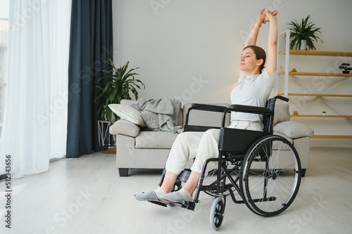 Brunette woman working out on wheelchair at home