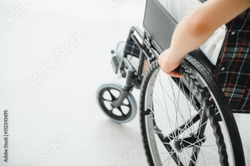 Woman in wheelchair's hand on wheel close up