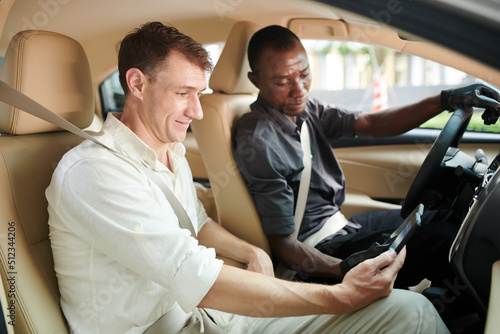 Happy passenger giving tips to driver via application on smartphone