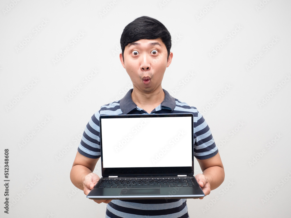 Young man amazed emotion holding laptop white screen isolated Young man amazed emotion holding laptop white screen isolated