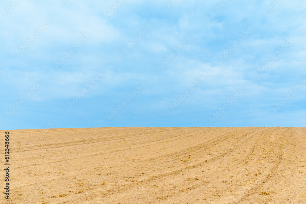 Landscape with agricultural land, in slope, recently plowed and prepared for the crop,agricultural background.Blue sky. Landscape with agricultural land, in slope, recently plowed and prepared for the crop,agricultural background.Blue sky.