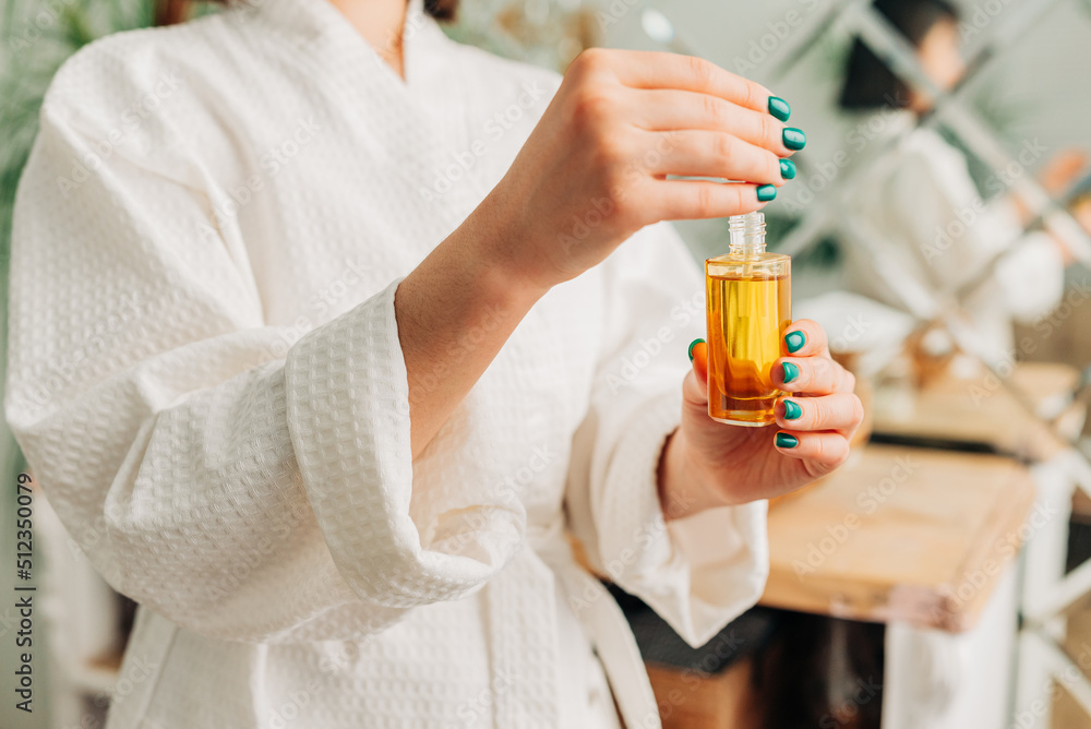 Facial Skincare. Happy Korean asian woman applying Facial serum using dropper standing in modern bathroom. Facial Skincare. Happy Korean asian woman applying Facial serum using dropper standing in modern bathroom.