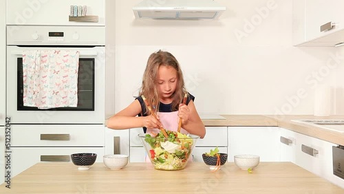 Cute girl preparing fresh vegetable salad.