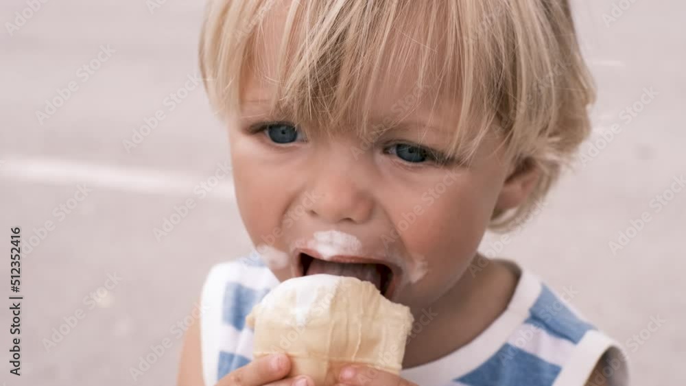 a small child eats white ice cream with great pleasure a small child eats white ice cream with great pleasure