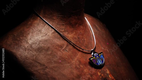 Beautiful colored necklace on a vintage mannequin on black background.