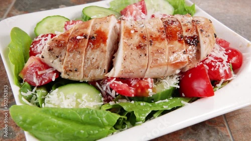 Grilled chicken breast high protein and delicious vegetable salad on white plate.