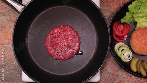 Juicy beef hamburger patties over hot pan.