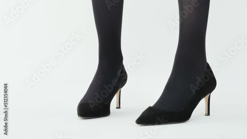 Catwalk in black high heels on white background.