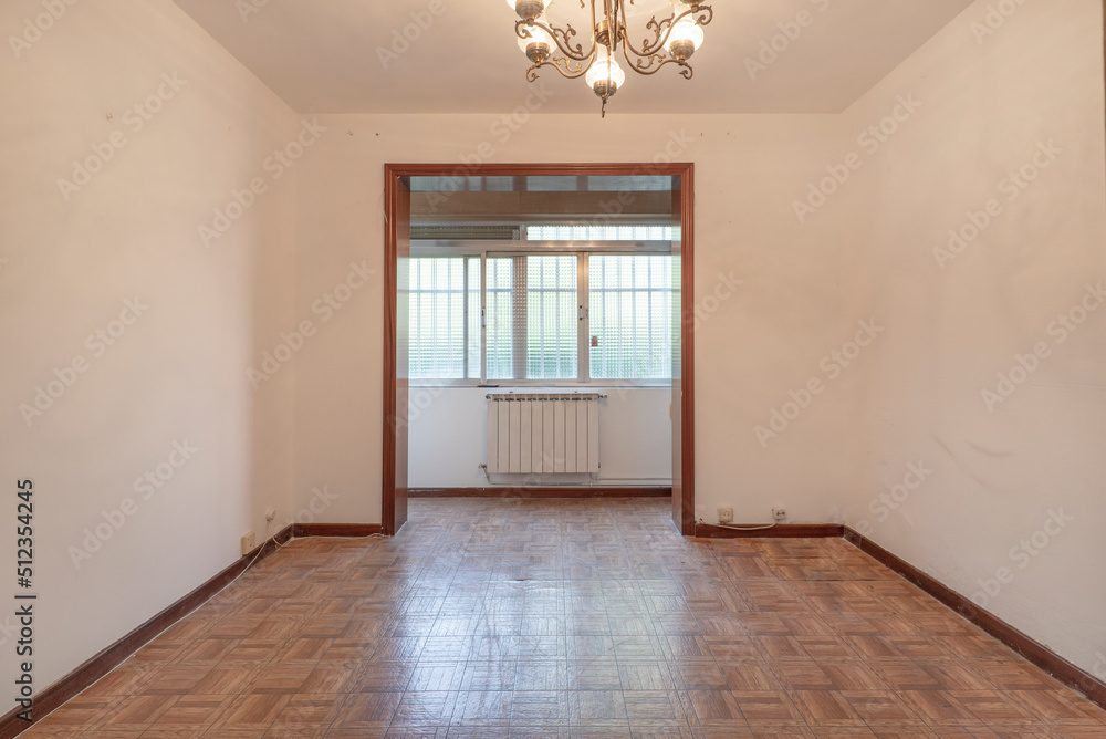 Fototapeta premium Empty living room with dark wood sliding doors and imitation wood sintasol floor and closed terrace with aluminum windows