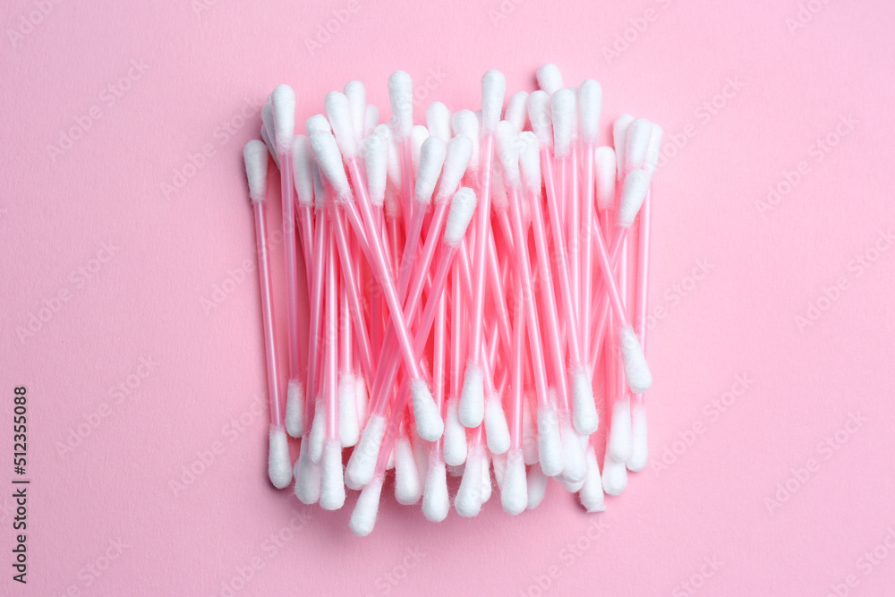 Heap of cotton buds on pink background, top view Heap of cotton buds on pink background, top view