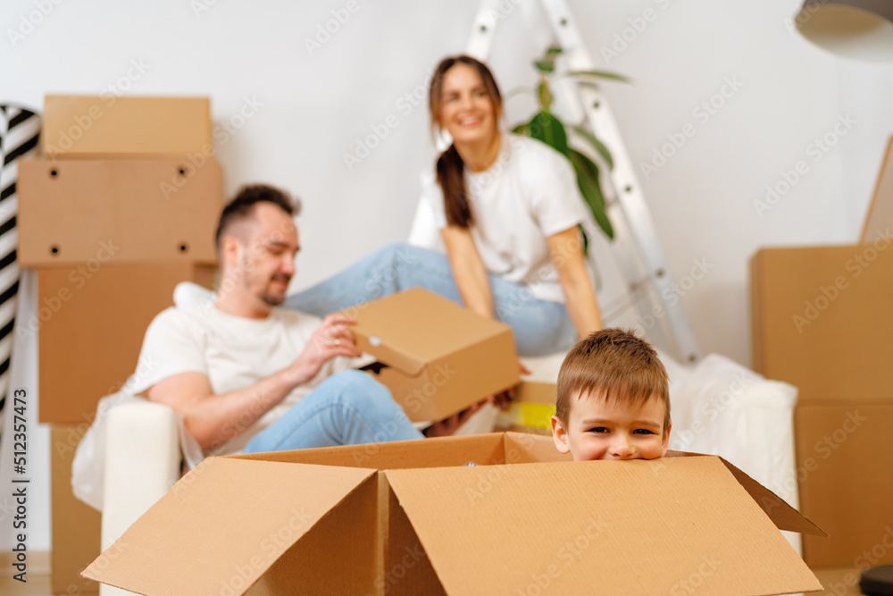 Parents and son packing boxes and moving into a new home Parents and son packing boxes and moving into a new home