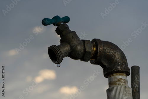 A drop of water from a water spigot during a drought
