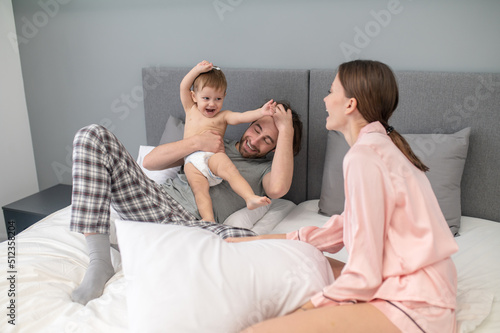 Woman looking at playful baby in mans arms