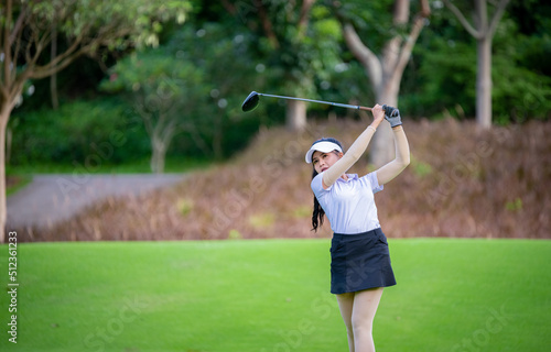 Professional woman golfer teeing golf in golf tournament competition at golf course for winner. 