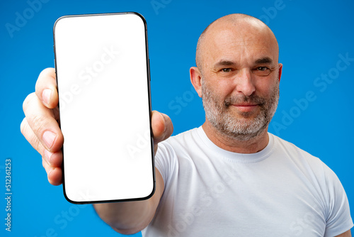 Εκτύπωση καμβά Middle-aged man showing blank smartphone screen with copy space against blue bac