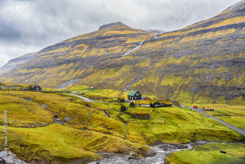 Small village,with houses with grass roofs, at the foot of the mountain. Faroe Islands. Denmark. Europe. Landscapes.