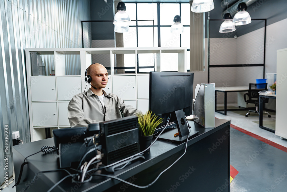 Young bald man working in a call center office Young bald man working in a call center office