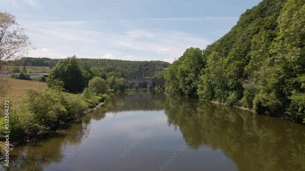 Aerial approach towards an old train trestle that connects the two banks of the Sieg in west Germany on a sunny spring day. Aerial approach towards an old train trestle that connects the two banks of the Sieg in west Germany on a sunny spring day.