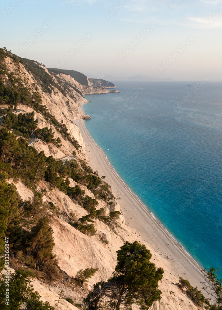 Beautiful wild Mediterranean pebble beach under a large massive cliff