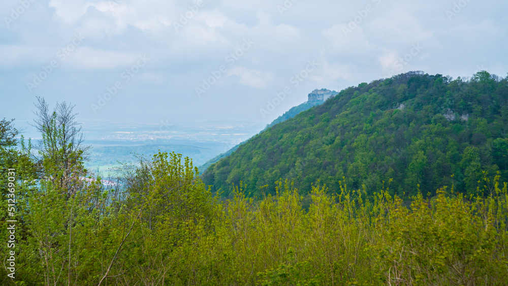 Germany, Historical hohenneuffen castle ruins nature landscape on top of a tree covered mountain in foggy atmoshpere, panorama view