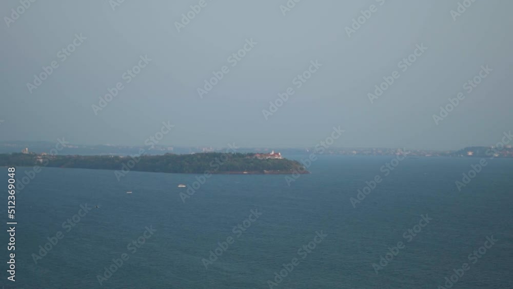 Wide angle shot of blue Arabian sea as seen from the Aguada Fort in Goa, India. Island as seen from top of the hill with sea surrounding it. Nature background with blue sea. Summer relaxation concept. Wide angle shot of blue Arabian sea as seen from the Aguada Fort in Goa, India. Island as seen from top of the hill with sea surrounding it. Nature background with blue sea. Summer relaxation concept.
