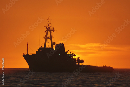 silhouette of a tug boat at sunset
