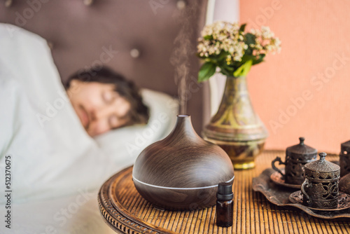 Aromatherapy Concept. Wooden Electric Ultrasonic Essential Oil Aroma Diffuser and Humidifier. Ultrasonic aroma diffuser for home. Man resting at home