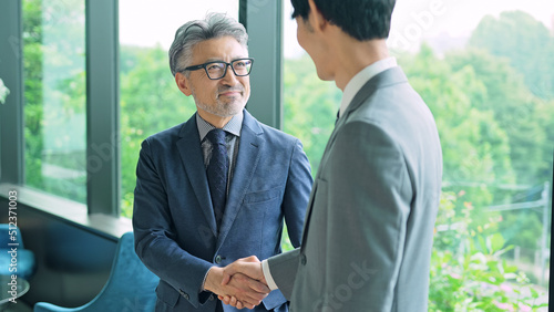 若いビジネスマンと握手するエグゼクティブ男性 photo