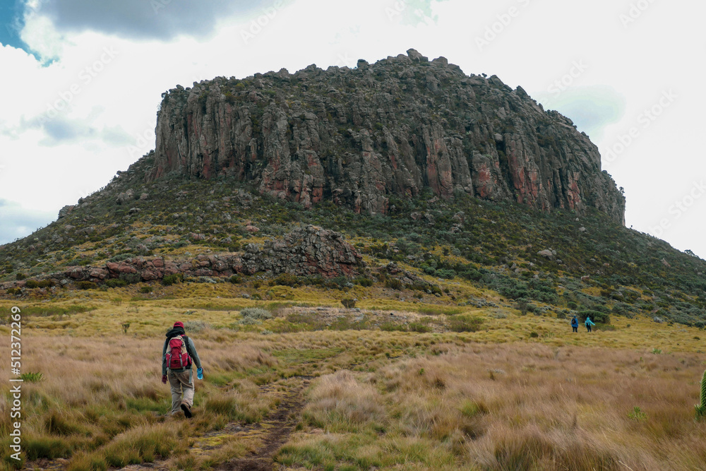 Rear view of a group of hikers against a mountain background at the Dragons Teeth at Ol Doinyo Lestima Mountain in Aberdares, Kenya