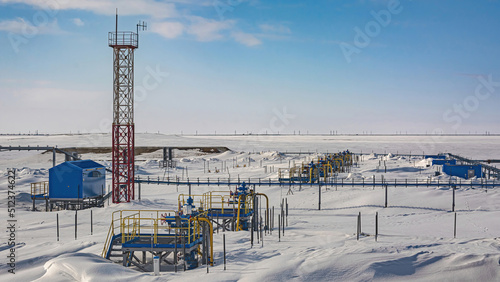 Wells producing natural gas at a field in the Arctic. Fountain equipment and technological strapping of a group of wells for gas production. Winter. Day. Gas production company infrastructure