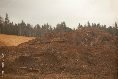 Fototapeta Naklejka Na Ścianę i Meble -  Mountain of sand on line. Excavated earth. Start of construction of road junction.
