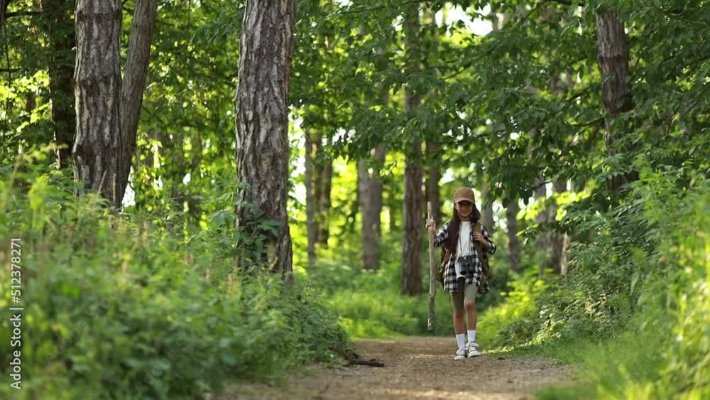 Girl scout traveling in the woods and walking with stick Girl scout traveling in the woods and walking with stick