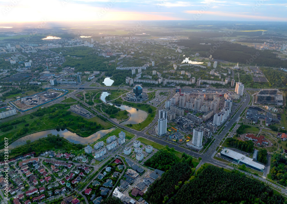 River in city on sunset, aerial view. Suburb houses and multi-storey residential buildings near river in Minsk, Belarus. Cottages and wooden suburb house. Suburban house on sunset panarama, drone view