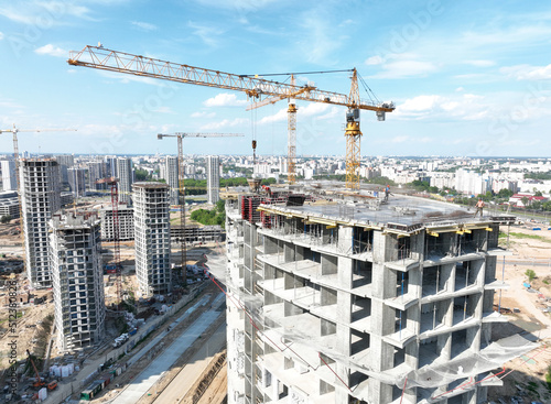 Сonstruction site with tower cranes on building construction. Builder on formworks. Cranes on pouring concrete in formwork. Tower cranes on construction in built environment. Buildings renovation..