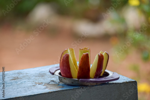 A red apple is sliced on a plate