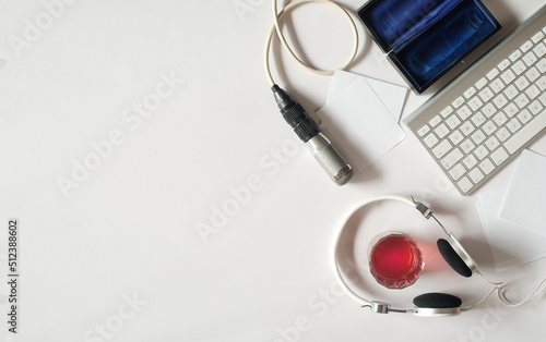 Podcasting concept, headphones, vintage microphone and computer keyboard on white background, free copy space