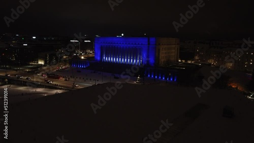 Winter night aerial rises over Helsinki Parliament House, blue lights photo