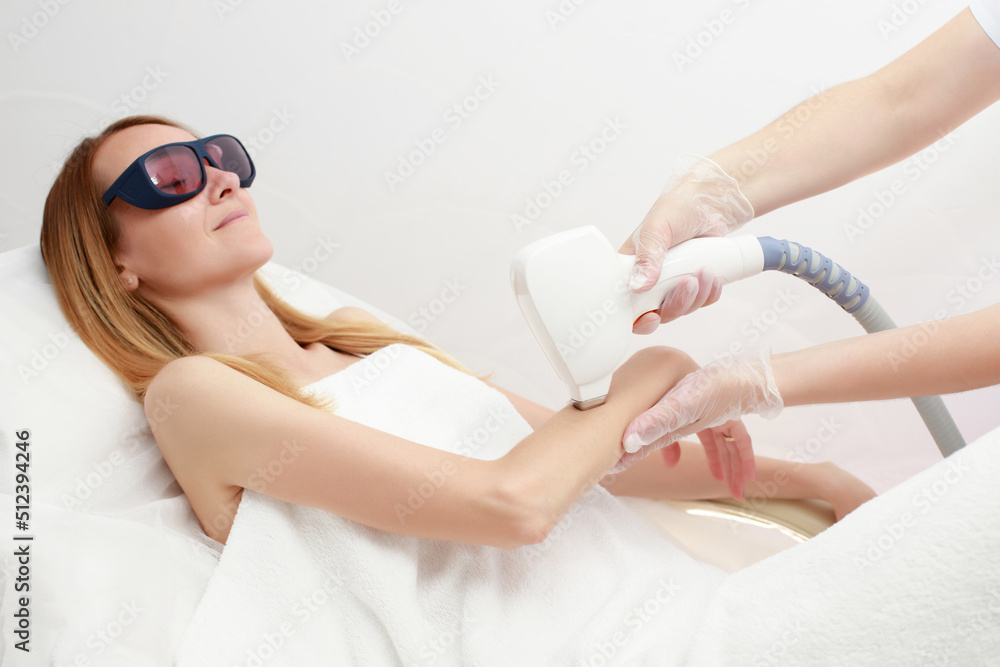 Diode laser hair removal, Beautician removes hair on beautiful female arm, Hair  removal for smooth skin, laser procedure. Photos | Adobe Stock