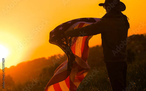 Fotografering Flag of the United Stands in the Hands of a Cowboy