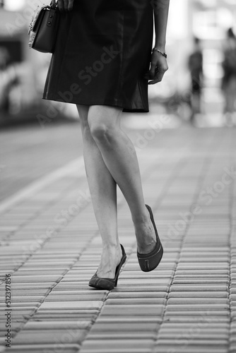 Slender female legs in the street in black and white