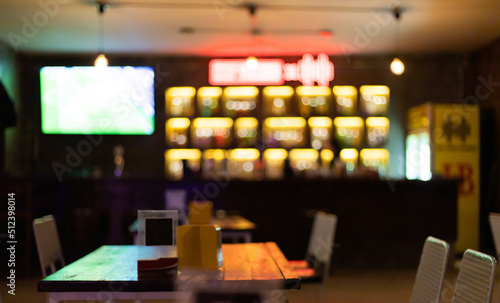 Image is blurred in a bar or tavern. Abstract image of an alcoholic beverage shop or pub. Colorful lighting in a store selling beer, alcohol, cocktails and a wide variety of beverages.