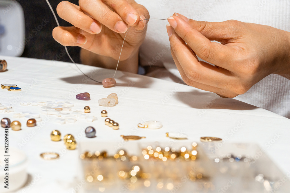 Hands of a person making a bracelet. Hands of a person making a bracelet.
